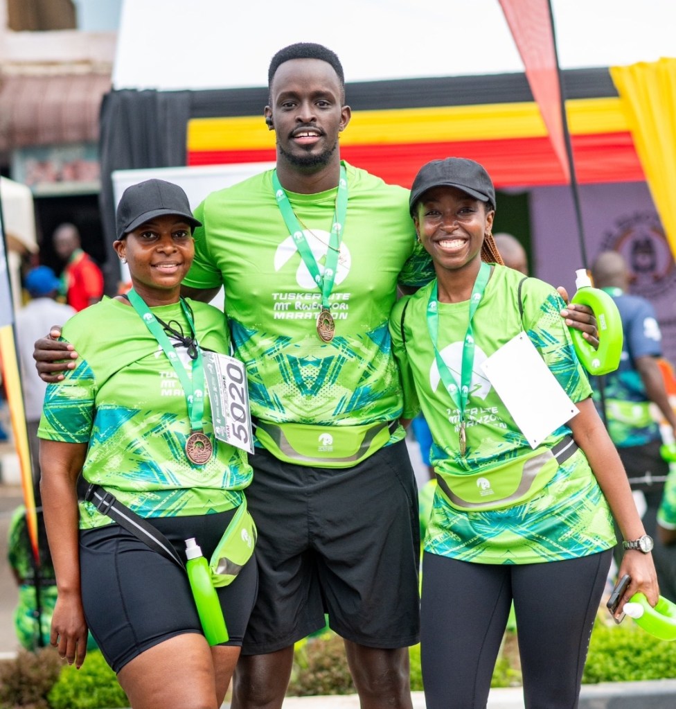 Madness in the Mountains: The Ultimate Mt. Rwenzori Marathon Guide & Where to Stay Three happy participants posing with finisher medals after the Rwenzori Marathon.