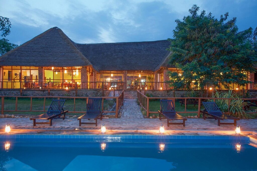 Madness in the Mountains: The Ultimate Mt. Rwenzori Marathon Guide & Where to Stay A night view of Voyager Equator Lodge with a pool . A perfect place for recovery for a marathon runner