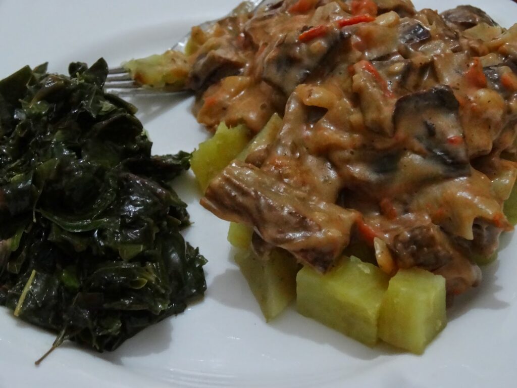 A plate of traditional Bagisu food featuring Malewa (bamboo shoots) and millet.