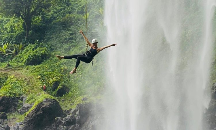 A lady tourist enjoying abseiling at the SIPI Falls in Mbale