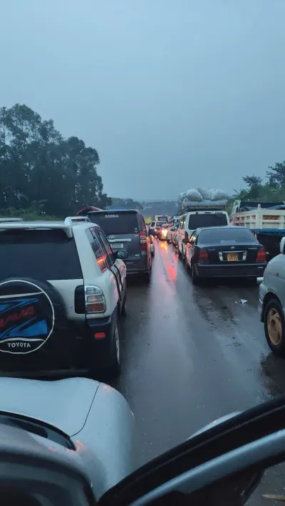 A busy Mbale-Kampala highway scene in Uganda with heavy traffic, including cargo cars and other  private cars,