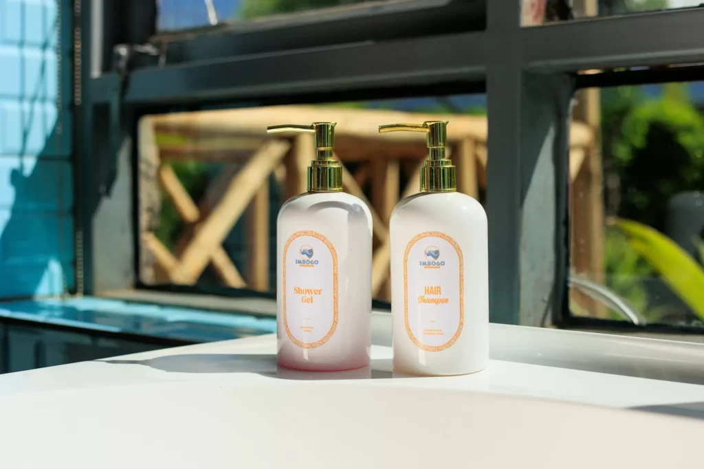 Imbogo Diners and Lounge luxury bathroom amenities showing branded shower gel and hair shampoo bottles on a sunlit counter
