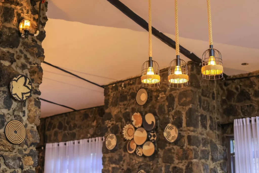Imbogo Diners and Lounge interior decor featuring rope-hung pendant lights and handcrafted African woven baskets on a volcanic stone wall