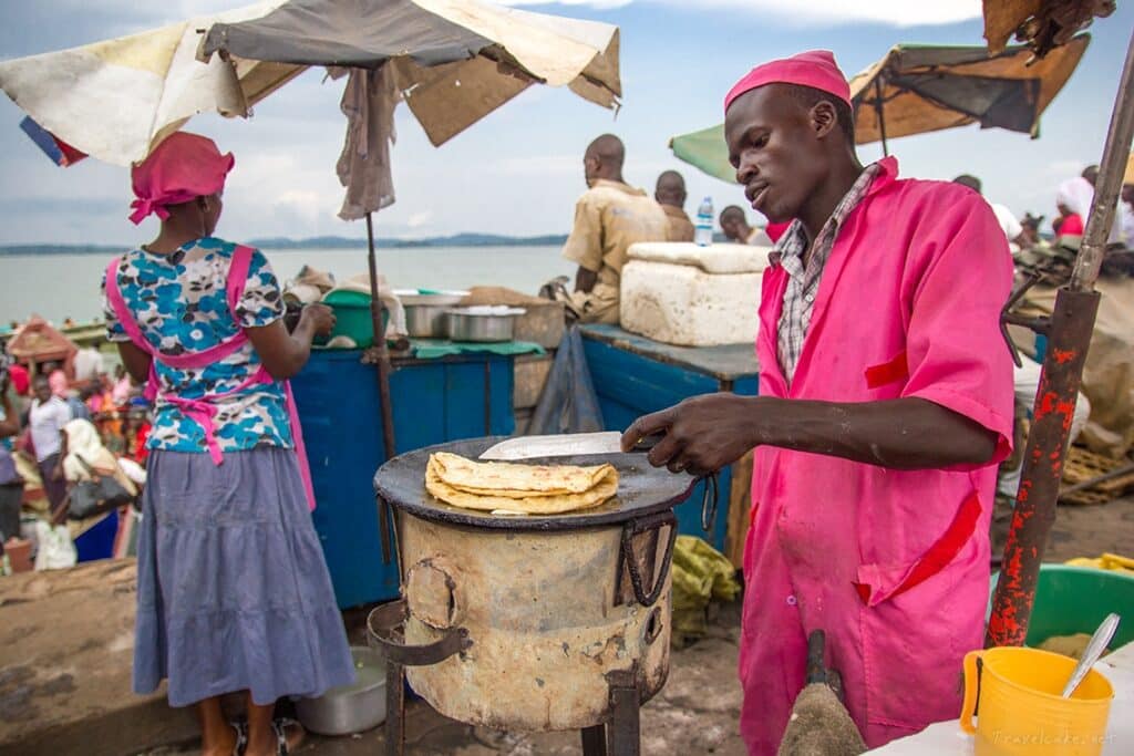 A local vendor preparing a fresh Ugandan rolex chapati on a roadside stall during a Jinja Uganda itinerary